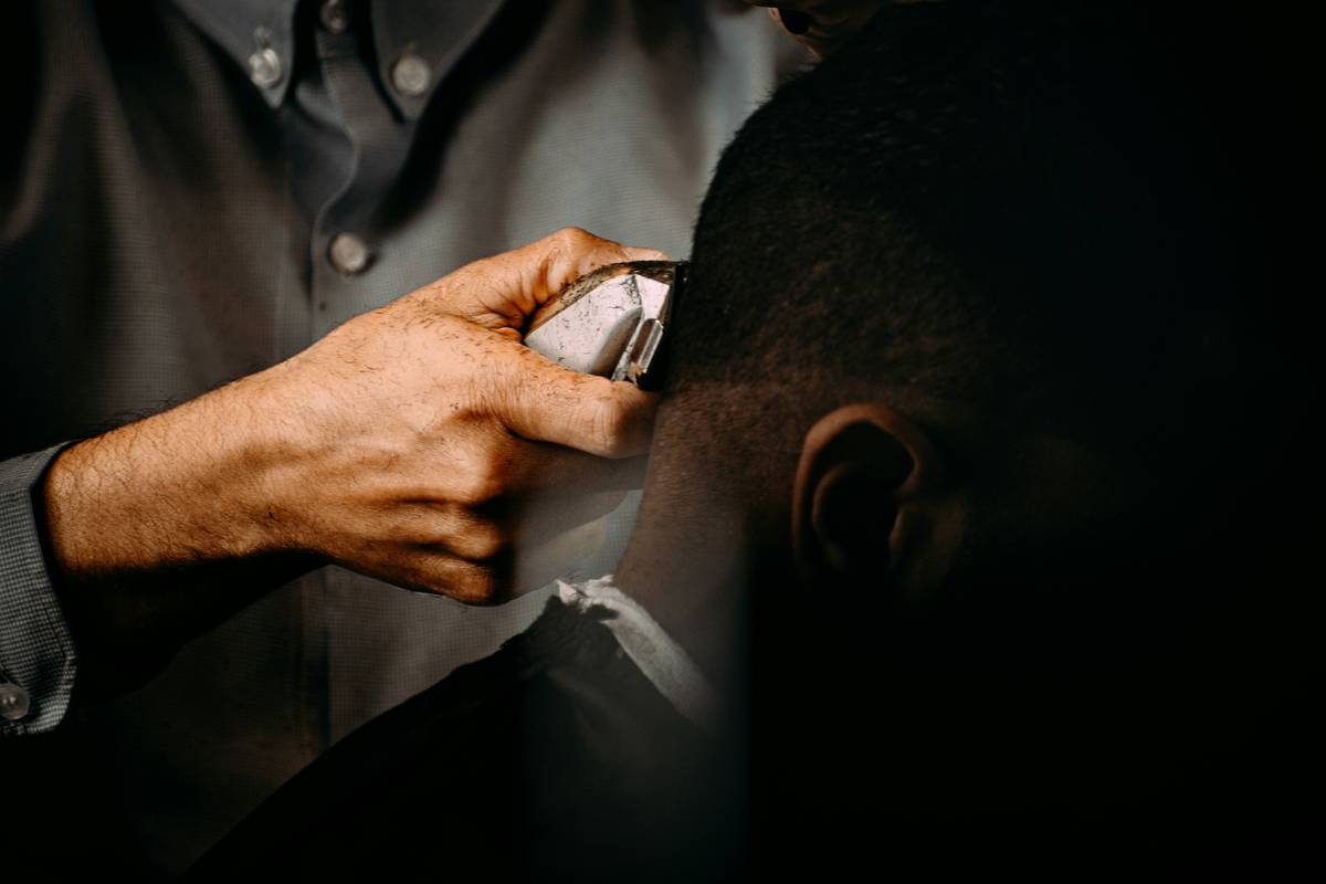 a man in a suit holding a pen to a man's ear