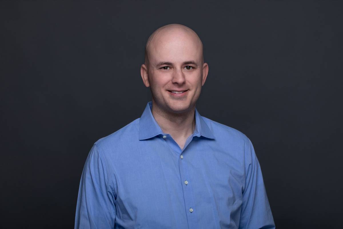a man in a blue shirt is smiling